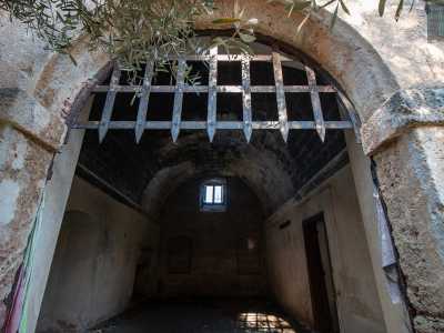 Decidiamo ora di entrare nell�edificio, il cui accesso ci lascia senza fiato. Siamo di fronte a un arco a tutto sesto dominato da una saracinesca a grata in ferro battuto, simile a quella che si vede nei film che hanno come protagonisti castelli e cavalieri